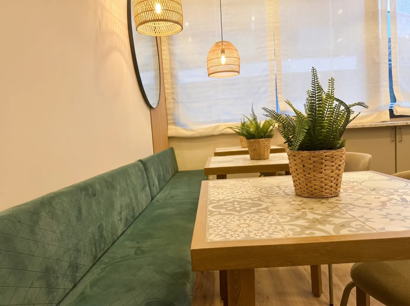 Green upholstered bench and tiled table in the breakfast area