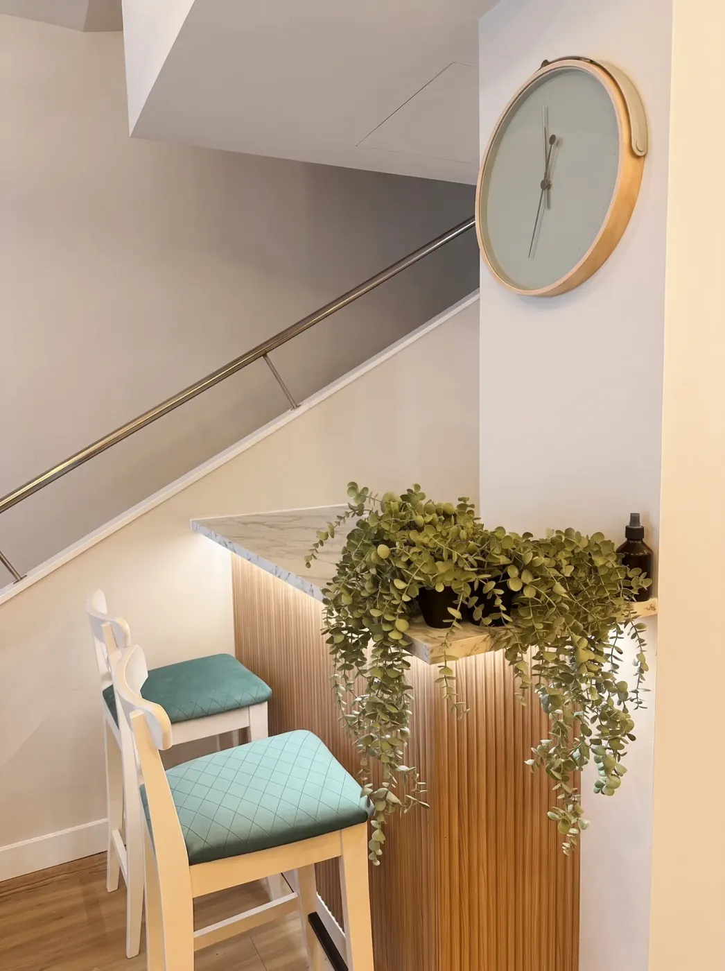Entrance staircase with a clock and plant in the hotel reception