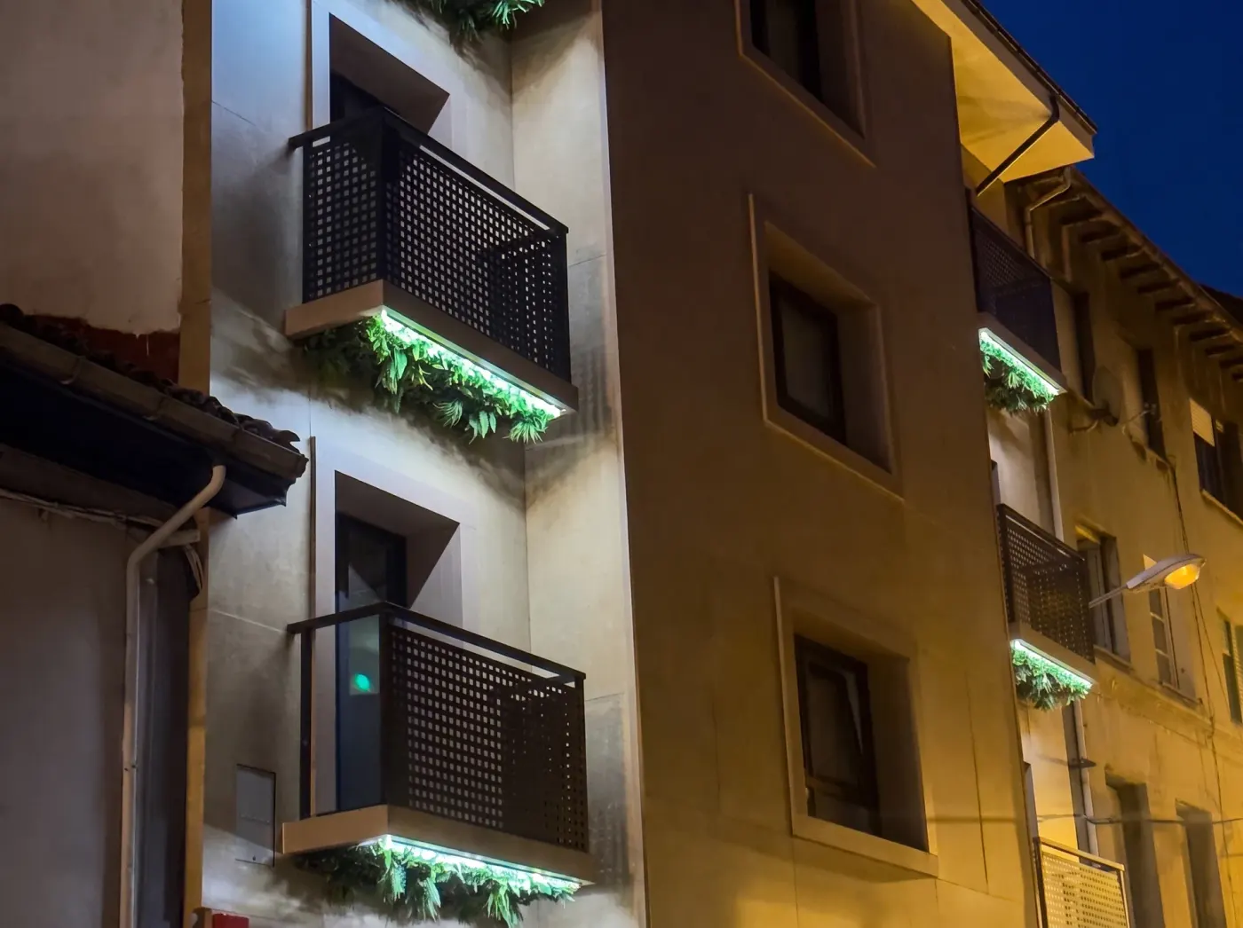 Balconies with lit planters on the hotel façade