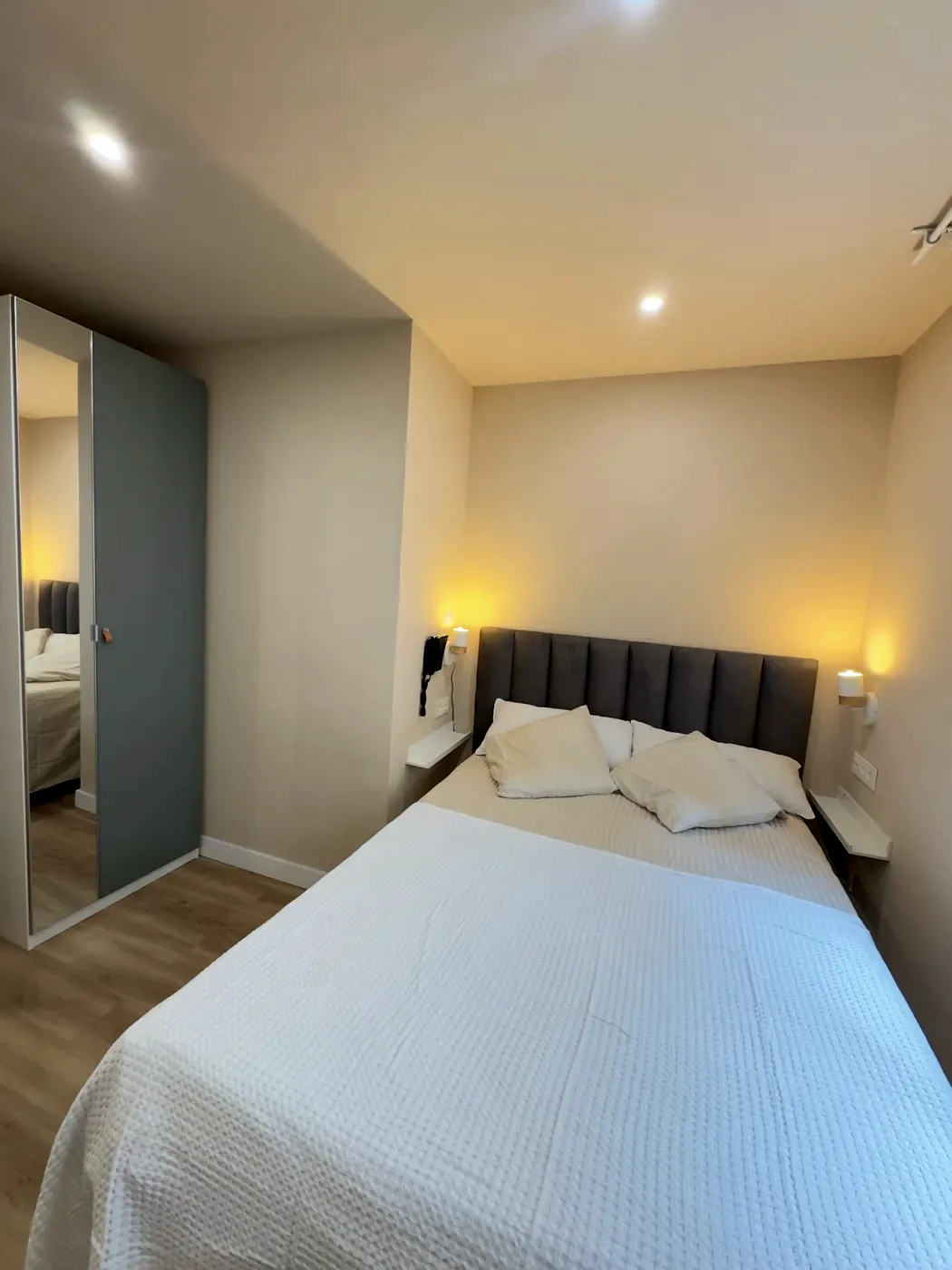 Double bed with upholstered headboard and reading lamps