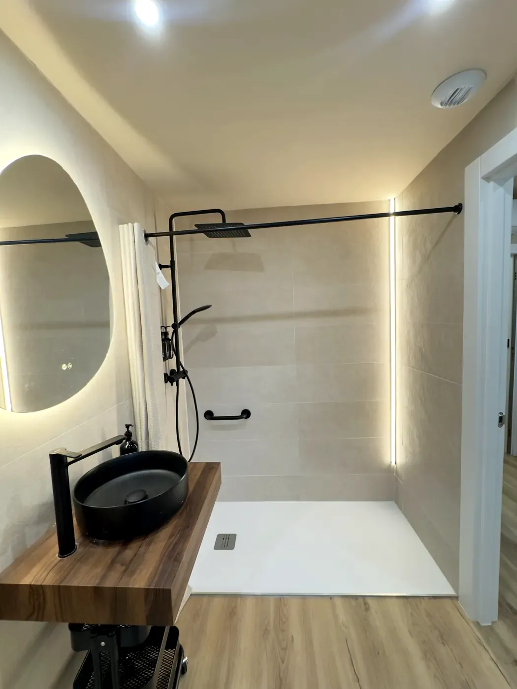 Flush-floor shower with rainfall tap and grab bar