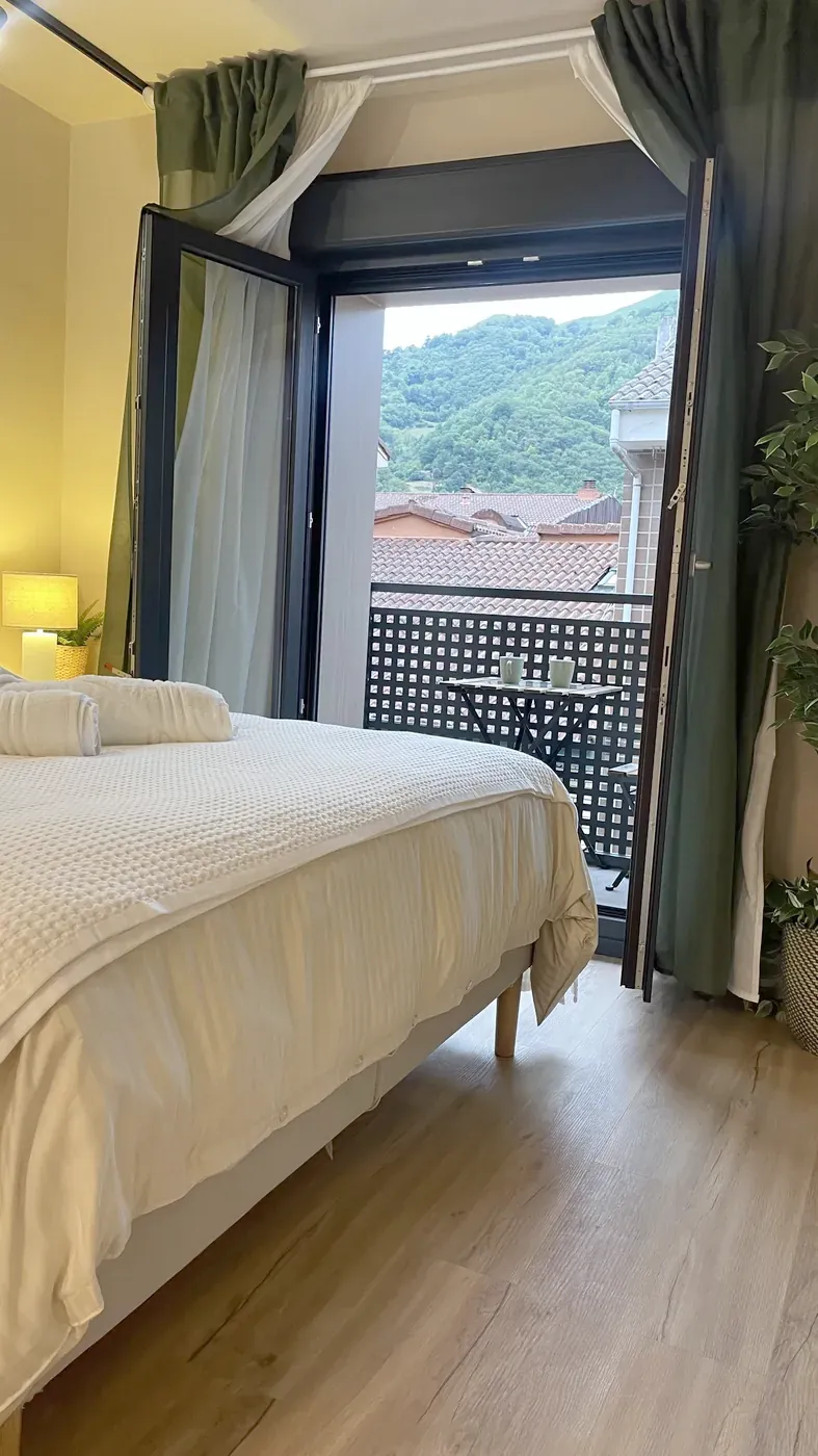 Suite bed with the balcony open onto the mountains