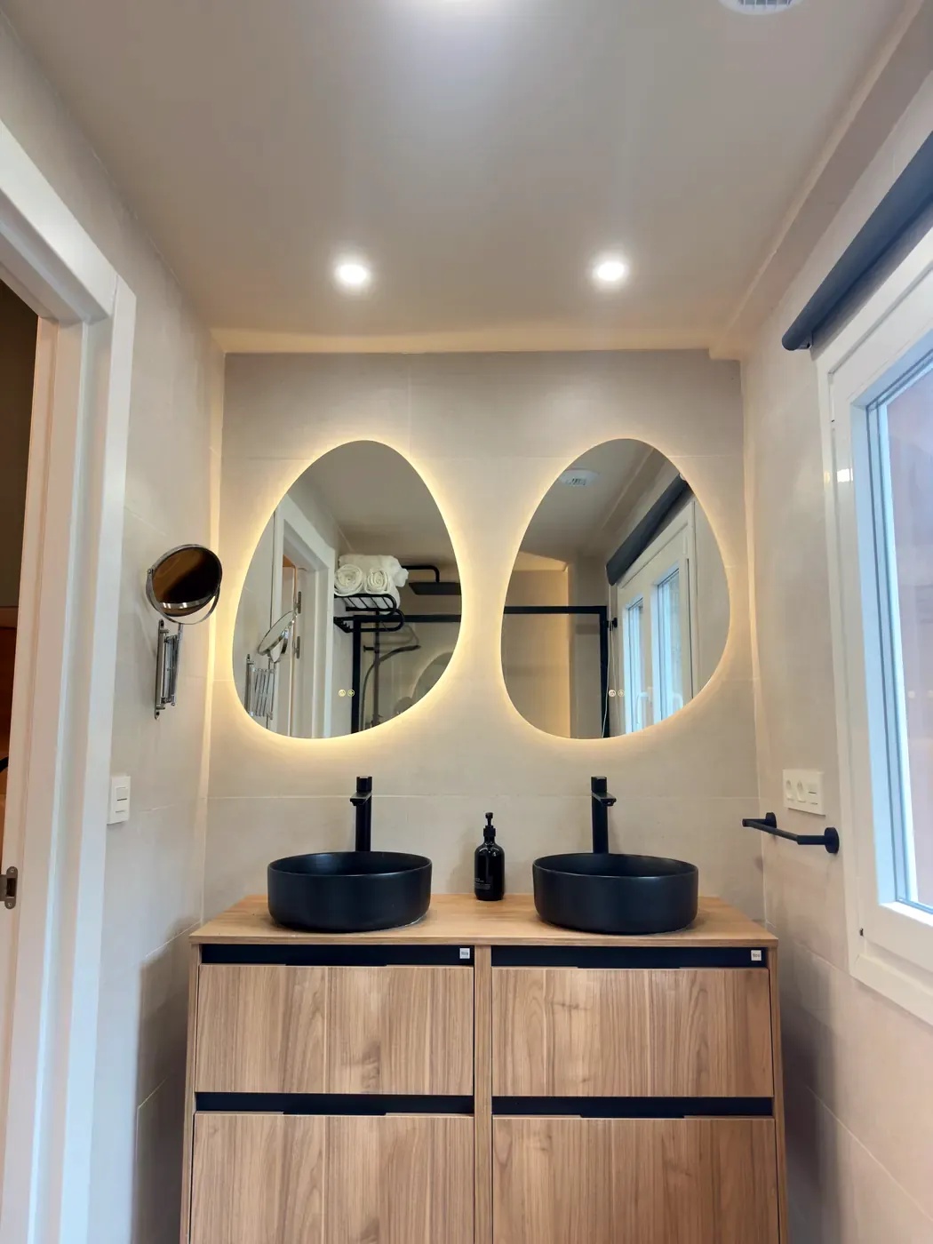 Suite bathroom with double washbasin and illuminated mirrors