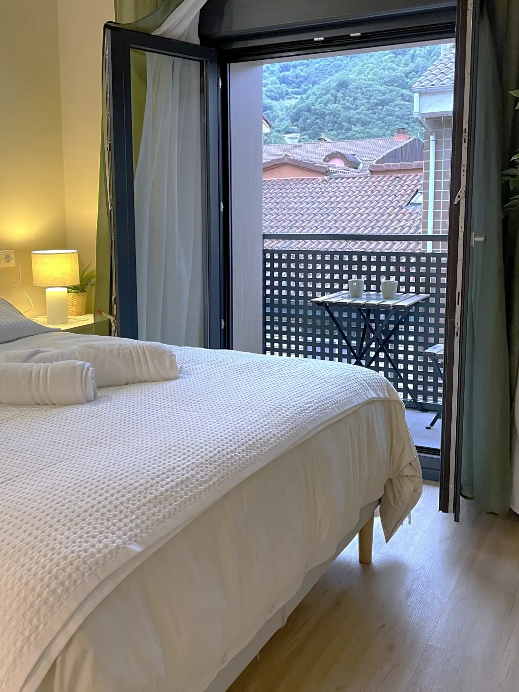 Suite bed with the balcony open onto the mountains
