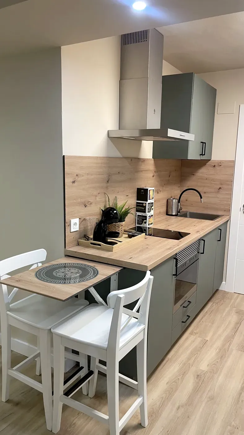 Fully equipped suite kitchen with a fold-down table and two stools