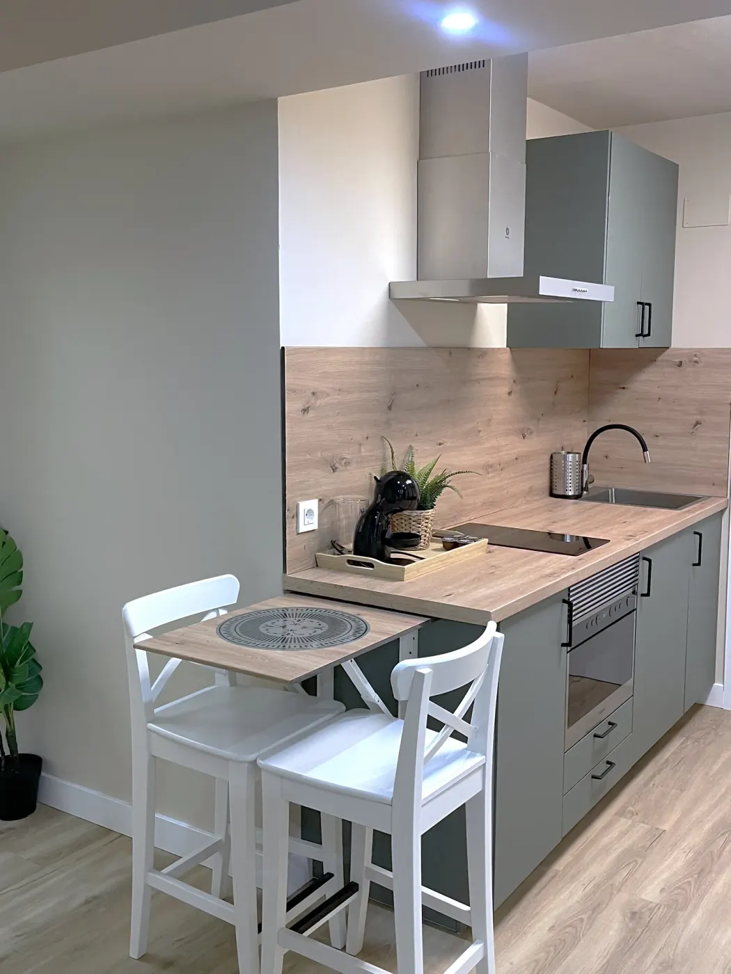 Fully equipped suite kitchen with a fold-down table and two stools